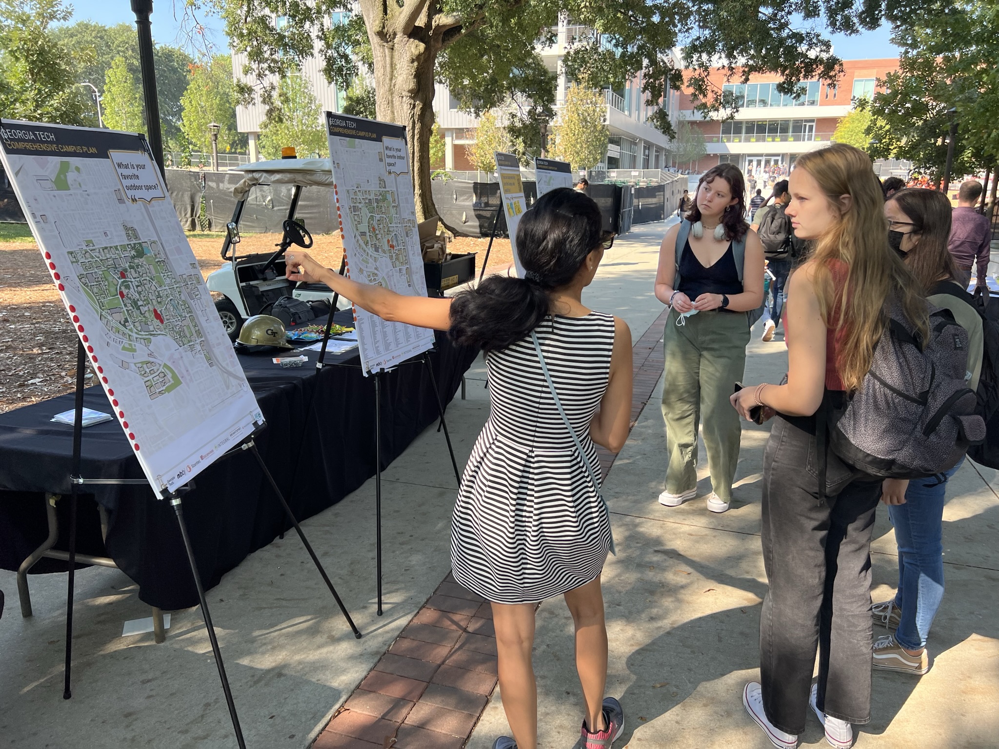 students discussing the campus plan signage